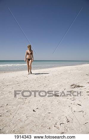 Stock Image - Woman Walking On Beach At Bean Point. Fotosearch