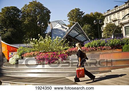 Stock Image - Woman Walking Past Sculpture At Piazza Solferino, Turin, Italy. Fotosearch