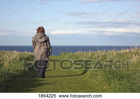 Stock Photography - Woman Walking Path To Seashore, South Shields, Tyne And Wear, England. Fotosearch