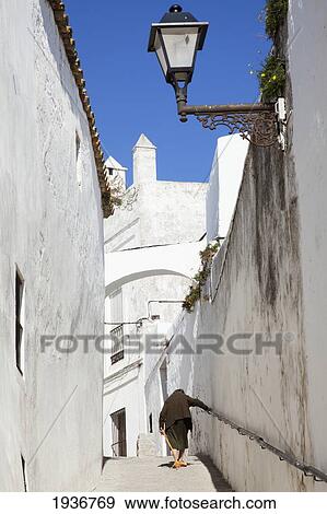 Stock Photo - Woman Walking Up Exterior Stairs; Vejer De La Frontera Spain. Fotosearch