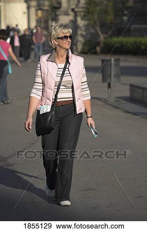 Stock Photo - Woman Walking Up La Rambla, Barcelona, Spain. Fotosearch