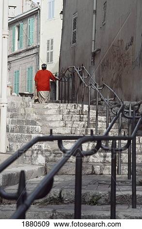 Stock Photo - Woman Walking Up Steps In Le Panier District. Fotosearch