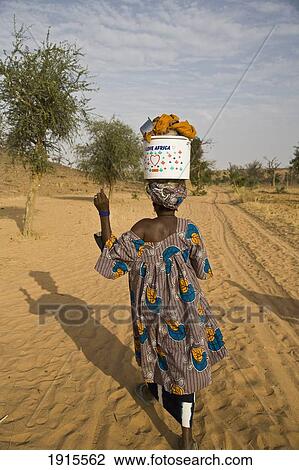 Woman Walking With Bucket On Head At Bandiagara Escarpment View Large Photo Image Stock Image - Woman Walking With Bucket On Head At Bandiagara Escarpment. Fotosearch