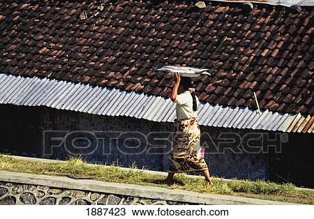 Stock Image - Woman Walking With Fish Over Head. Fotosearch