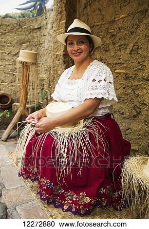 Stock Image - Woman weaving a panama hat from toquilla straw at the Homero Ortega Panama Hat Factory, Cuenca, Azuay, Ecuador. Fotosearch