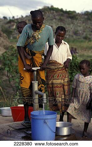 Stock Image - Woman With Baby On Her Back Pumping Water Fron A New Well, Nr Mwanza, Tanzania. Fotosearch