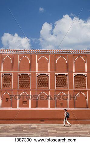Stock Image - Woman With Backpack Walking Past Wall Of The City Palace. Fotosearch