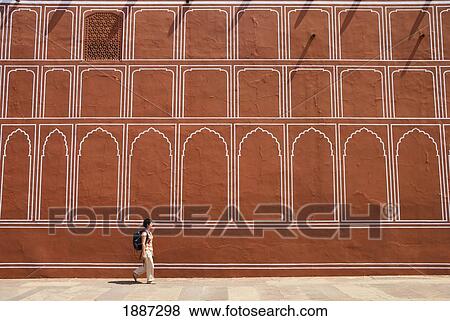 Stock Photo - Woman With Backpack Walking Past Wall Of The City Palace. Fotosearch