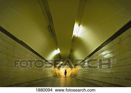 Picture - Woman With Bag On Head Walking Through Pedestrian Tunnel. Fotosearch