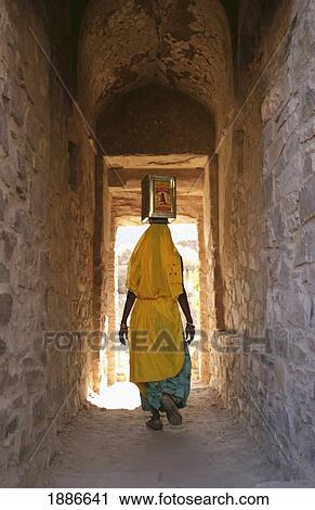 Woman With Box On Her Head Walking Through Alleyway View Large Photo Image Stock Image - Woman With Box On Her Head Walking Through Alleyway. Fotosearch