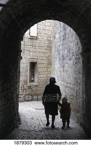 Stock Image - Woman With Child In Old Town Alley. Fotosearch