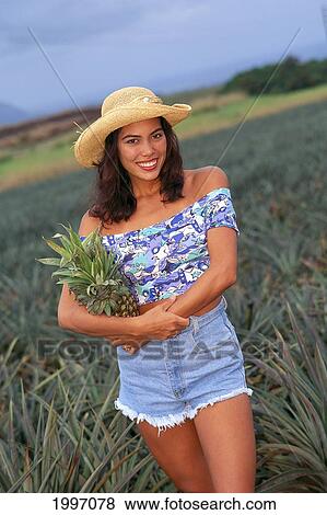 Stock Photo - Woman With Hat, Holding Pineapple In Fields A03G. Fotosearch