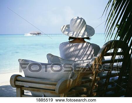 Woman With Hat Sitting In Shade On Beach View Large Photo Image Stock Photo - Woman With Hat Sitting In Shade On Beach. Fotosearch