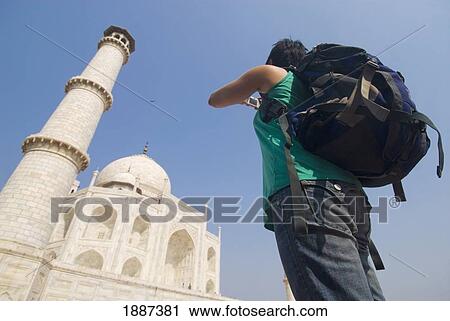 Stock Image - Woman With Rucksack Photographing The Taj Mahal, Low Angle View. Fotosearch