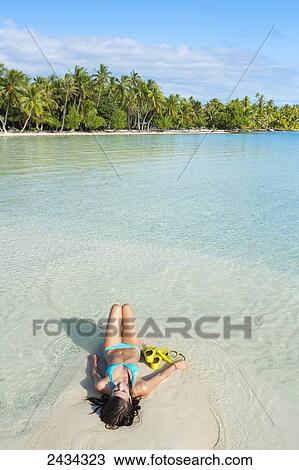 Woman with snorkel gear laying on white sand in aqua blue water; Tahaa, French Polynesia View Large Photo Image Stock Image - Woman with snorkel gear laying on white sand in aqua blue water; Tahaa, French Polynesia. Fotosearch