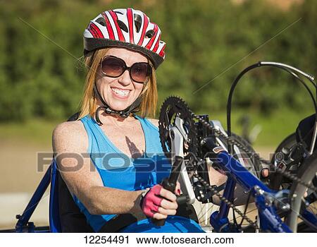 Stock Image - Woman with spinal cord injury cycling using hand propelled bicycle; Edmonton, Alberta, Canada. Fotosearch