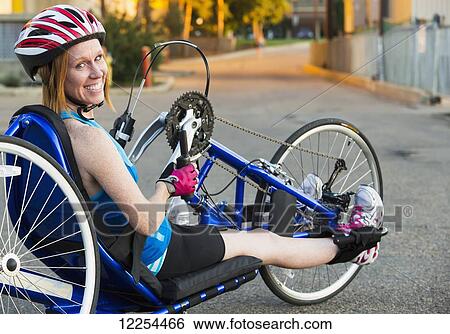 Stock Photograph - Woman with spinal cord injury cycling using hand propelled bicycle; Edmonton, Alberta, Canada. Fotosearch