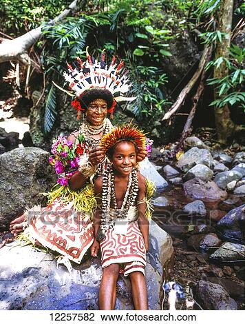 Stock Image - Woman with tattooed face and young boy in traditional dress; Tufi, Papua New Guinea. Fotosearch