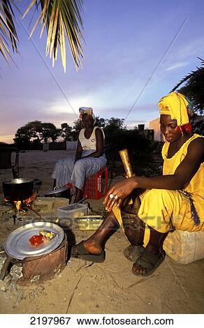 Stock Photo - Women Cooking Food Outside Infront Of Sunset, Dalaba Lodge, Ginak Island, The Gambia. Fotosearch