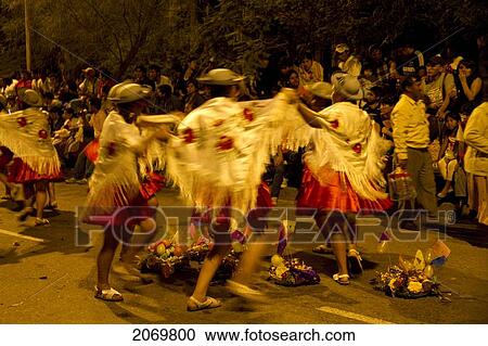 Stock Image - Women Dancing Around Festive Baskets In The Gran Entrada De Comadres Parade During The Carnaval Chapaco At Night, Tarija, Bolivia. Fotosearch