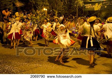 Stock Image - Women Dancing In The Gran Entrada De Comadres Parade During The Carnaval Chapaco At Night, Tarija, Bolivia. Fotosearch
