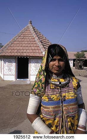 Stock Image - Women Dressed In Colourful Saris Wearing Necklace And Many Bracelets Standing In Front Of A House, Harijan Woman, Bhirandiara, North Of Bhuj. Fotosearch