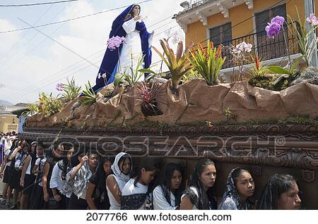 Stock Photograph - Women Dressed In Mourning Carry The Anda (Float) Of The Virgin Mary During The Procession Of The Holy Cross On Good Friday In Antigua Guatemala, Sacatep. Fotosearch