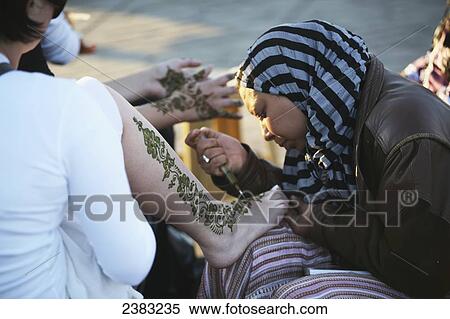 Women having henna put on their legs and hands at main square Djemma el Fna at sundown; Marrakesh; Morocco View Large Photo Image Stock Photography - Women having henna put on their legs and hands at main square Djemma el Fna at sundown; Marrakesh; Morocco. Fotosearch