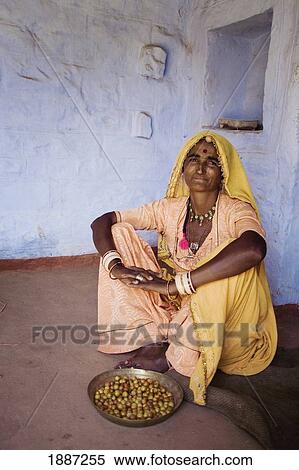 Stock Photography - Women In Yellow Sari With Bowl Of Food. Fotosearch