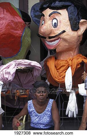 Stock Photo - Women Infront Of Over-Sized Carnival Manikin Heads. Fotosearch