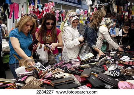 Stock Photo - Women shop for ripoff and fake purses at Carsamba Pazari, the Wednesday Market in Fatih is one of Istanbul's oldest and most colourful market places, which is located around a network of streets surrounding the Fatih Mosque in Istanbul, Turkey. Photo. Fotosearch