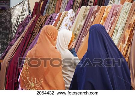 Stock Image - Women Shopping For Fabrics In The Bazaar, Rosetta (Rashid), Beheira, Egypt. Fotosearch