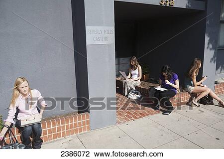 Women sit on a brick ledge outside a building for casting auditions; Beverly Hills, California, United States of America View Large Photo Image Stock Image - Women sit on a brick ledge outside a building for casting auditions; Beverly Hills, California, United States of America. Fotosearch