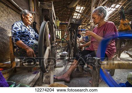 Women spinning yarn at a lurik fabric workshop in Cawas village, Klaten, Central Java, Indonesia View Large Photo Image Picture - Women spinning yarn at a lurik fabric workshop in Cawas village, Klaten, Central Java, Indonesia. Fotosearch