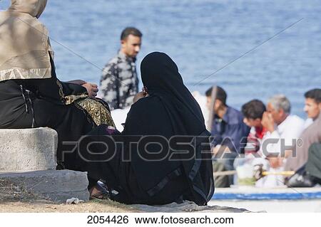 Stock Photograph - Women Waiting For A Boat On The Shores Of The Rosetta Branch Of The Nile River, Rosetta (Rashid), Beheira, Egypt. Fotosearch