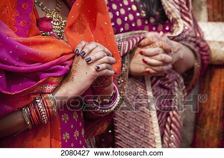 Stock Photo - Women Waiting With Hands Folded At An Indian Wedding; Ludhiana, Punjab, India. Fotosearch