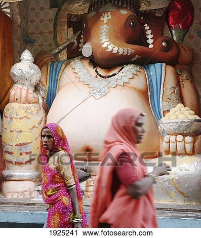 Women Walking Past Statue Of Ghanesh, Deogarh Village, Rajasthan, India View Large Photo Image Stock Image - Women Walking Past Statue Of Ghanesh, Deogarh Village, Rajasthan, India. Fotosearch