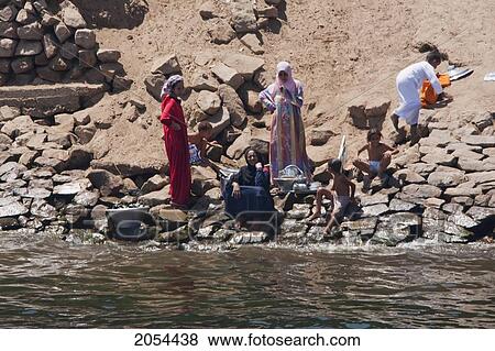 Women Washing Clothes By The Shore Of The Nile River Between Aswan And Edfu, Aswan, Egypt View Large Photo Image Stock Photo - Women Washing Clothes By The Shore Of The Nile River Between Aswan And Edfu, Aswan, Egypt. Fotosearch