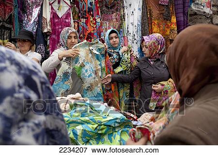 Stock Photo - Women wearing headscarfs shopping at Carsamba Pazari, the Wednesday Market in Fatih is one of Istanbul's oldest and most colourful market places, which is located around a network of streets surrounding the Fatih Mosque in Istanbul, Turkey. Photo. Fotosearch