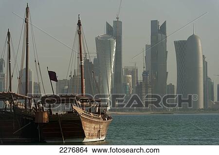 Wooden boats in the harbour with the modern skyline of Doha behind; Doha, Qatar View Large Photo Image Picture - Wooden boats in the harbour with the modern skyline of Doha behind; Doha, Qatar. Fotosearch