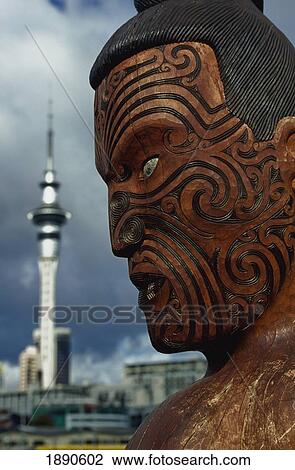 Stock Image - Wooden Carving Of Maori Head With Tattoos, Close-Up. Fotosearch