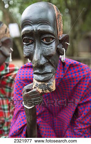 Stock Photo - Wooden carving of tribesman in colorful fabric; Nairobi, Kenya. Fotosearch