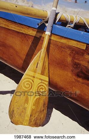Wooden paddle and outrigger canoe on beach View Large Photo Image Stock Photo - Wooden paddle and outrigger canoe on beach. Fotosearch