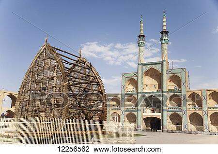 Stock Image - Wooden palm leaf (Nakhl) in front of Amir Chaqmaq; Yazd, Iran. Fotosearch