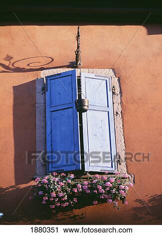 Stock Image - Wooden Shutters And Window Box On Orange Building, Close-Up. Fotosearch