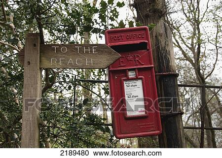 Stock Image - Wooden Sign And Red Uk Postal Box Along The South West Coast Path Near Lynmouth, Exmoor, United Kingdom. Fotosearch