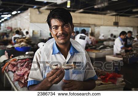 Picture - Worker in a fish market; Dubai, United Arab Emirates. Fotosearch