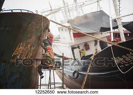 Workers reparing a fishing boat in the shipyard; Xiapu, Fujian, China View Large Photo Image Stock Image - Workers reparing a fishing boat in the shipyard; Xiapu, Fujian, China. Fotosearch