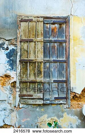 Stock Photo - Worn wooden shutters on a cracked and dilapidated building; Beirut, Lebanon. Fotosearch