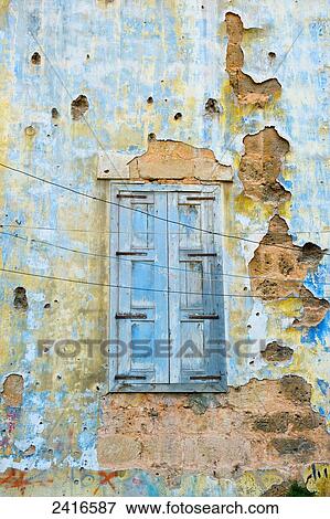 Stock Photo - Worn wooden shutters on a cracked and dilapidated building; Beirut, Lebanon. Fotosearch